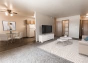 Thumbnail 2 of 19 - Grand Forks, ND Cherry Creek Apartments a living room with a white rug and white furniture with a dining room in the background