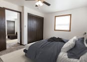 Thumbnail 4 of 8 - Grand Forks, ND Claremont Apartments. a bedroom with a bed and a ceiling fan