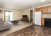 Thumbnail 2 of 10 - Grand Forks, ND Columbia West Apartments a living room with a white refrigerator freezer next to a stove top oven