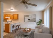 Thumbnail 2 of 17 - A living room with a couch and a table in front of a kitchen. Grand Forks, ND Creekside Apartments.