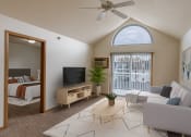 Thumbnail 1 of 17 - a living room with a couch and a tv and a bedroom. Grand Forks, ND Creekside Apartments.