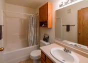 Thumbnail 15 of 17 - Grand Forks, ND Creekside Apartments. A bathroom with a sink and a toilet and a shower