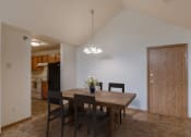 Thumbnail 3 of 17 - A dining room and kitchen with a wooden table and chairs. Grand Forks, ND Creekside Apartments.
