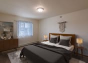 Thumbnail 4 of 17 - A bedroom with a bed and a dresser and a window. Grand Forks, ND Creekside Apartments.