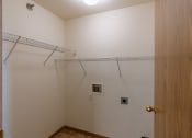 Thumbnail 11 of 17 - Grand Forks, ND Creekside Apartments. A closet with two shelves and laundry hookups
