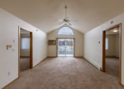 Thumbnail 6 of 17 - Grand Forks, ND Creekside Apartments. A living room with a ceiling fan and a balcony