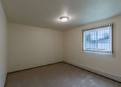 Thumbnail 15 of 19 - Grand Forks, ND Grandview Apartments. A bedroom with carpeted floors and a window.