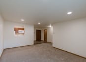Thumbnail 10 of 19 - Grand Forks, ND Grandview Apartments. A living room with the kitchen and entry door in the background.