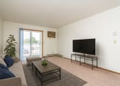 Thumbnail 4 of 19 - Grand Forks, ND Grandview I Apartments. a living room with white walls and a sliding glass door leading to a balcony
