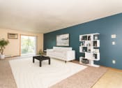 Thumbnail 1 of 19 - Grand Forks, ND Grandview I Apartments. a living room with a blue wall and a white couch and coffee table