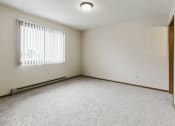 Thumbnail 11 of 28 - Grand Forks Harrison Apartments. A bedroom with a window and closet.
