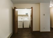 Thumbnail 13 of 28 - Grand Forks Harrison Apartments. A dining room with a door open to a kitchen and laundry room
