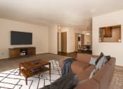 Thumbnail 2 of 12 - Grand Forks Kremer Apartments  A living room with a couch, coffee table, and tv with a dining area in the background
