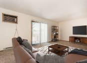 Thumbnail 3 of 12 - Grand Forks Kremer Apartments. A living room with a couch and a coffee table with a glass sliding door.