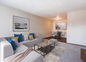 Thumbnail 2 of 20 - Grand Forks, ND Library Lane Apartments a living room with a couch coffee table and dining room table in the background