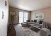 Thumbnail 1 of 20 - Grand Forks, ND Library Lane Apartments a living room with a gray couch and a coffee table with a glass sliding door