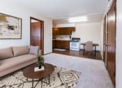 Thumbnail 6 of 20 - Grand Forks, ND Library Lane Apartments a living room with a couch and a table