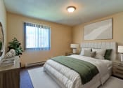 Thumbnail 4 of 12 - a bedroom with bed, dresser, and a window. Grand Forks, ND Madison Apartments