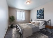 Thumbnail 4 of 16 - Grand Forks, ND Mayfair Apartments a bedroom with a large bed and a blue painting on the wall