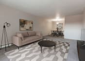 Thumbnail 1 of 16 - Grand Forks, ND Mayfair Apartments a living room with a couch and a table