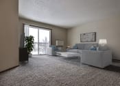Thumbnail 2 of 25 - Grand Forks Primrose Apartments.  a living room with a couch and a chair with a glass sliding door