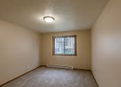 Thumbnail 24 of 28 - Grand Forks, ND Richfield Apartments. A bedroom with carpeted floors and a window.