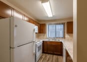 Thumbnail 21 of 28 - Grand Forks, ND Richfield Apartments. A kitchen with white appliances and a window.