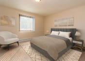 Thumbnail 4 of 10 - Grand Forks, ND Ridgemont Apartments. a bedroom with a bed and a chair