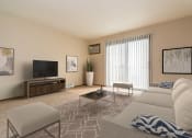 Thumbnail 3 of 10 - Grand Forks, ND Ridgemont Apartments. a living room with beige walls and a large glass slidng door