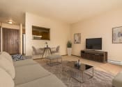 Thumbnail 2 of 10 - Grand Forks, ND Ridgemont Apartments. A living room with a couch table and chairs and a flat screen tv