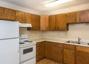 Thumbnail 6 of 10 - Grand Forks Ridgemont Apartments. A kitchen with white appliances.