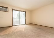 Thumbnail 5 of 10 - Grand Forks Ridgemont Apartments. A living room with a glass sliding door and an air conditioner on the wall