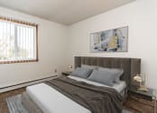Thumbnail 2 of 23 - Grand Forks, ND Riverwood Apartments. A bedroom with a bed and a large window