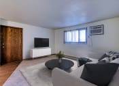 Thumbnail 5 of 19 - Grand Forks, ND Roughrider Apartments. a living room with white walls and a tv on the wall