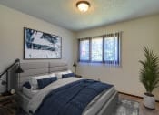 Thumbnail 4 of 19 - Grand Forks, ND Roughrider Apartments.  a bedroom with a large bed and two windows