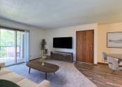 Thumbnail 2 of 19 - Grand Forks, ND Roughrider Apartments. a living room with a couch a table and a tv
