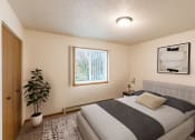 Thumbnail 3 of 22 - a bedroom with a bed and a potted plant. Grand Forks, ND Southview III Apartments.
