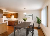 Thumbnail 2 of 22 - A dining room and kitchen with a table and chairs. Grand Forks, ND Southview Apartments.