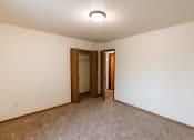 Thumbnail 11 of 22 - Grand Forks, ND Southview III Apartments. A room with carpet and a door to a hallway