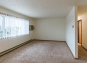 Thumbnail 7 of 22 - Grand Forks, ND Southview III Apartments. A living room of an apartment with carpet and a window