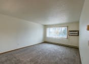 Thumbnail 18 of 22 - Grand Forks, ND Southview Apartments. A living room with a large window and air conditioning on the wall.
