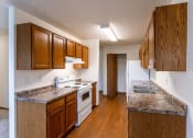Thumbnail 8 of 22 - Grand Forks, ND Southview III Apartments. A kitchen with white appliances and granite counter tops
