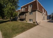 Thumbnail 10 of 10 - Grand Forks, ND Stanford Apartments. an apartment building with balconies and a large lawn