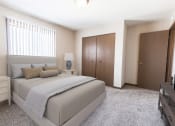 Thumbnail 7 of 27 - Grand Forks, ND Sunview apartments.  a bedroom with a bed and two nightstands with a closet and a window