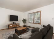 Thumbnail 3 of 6 - Grand Forks, ND Valley Home Duplex.  a living room with a couch and coffee table and a tv on the wall