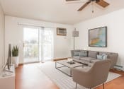Thumbnail 2 of 10 - Grand Forks, ND Vista Apartments.  A living room with a couch, chair, tv, and a sliding glass door