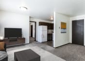 Thumbnail 2 of 8 - a living room with a tv and a kitchen in the background