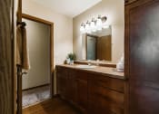 Thumbnail 12 of 17 - Grand Forks, ND Grandview II Apartments. A bathroom with a sink and dark cabinets