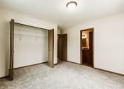 Thumbnail 9 of 17 - Grand Forks, ND Grandview II Apartments. A bedroom with a closet and bathroom.