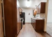Thumbnail 5 of 17 - Grand Forks, ND Grandview II Apartments. A kitchen with black appliances.